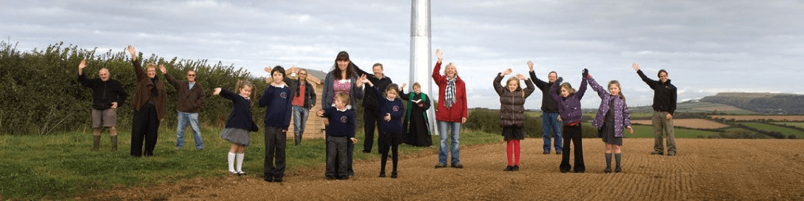 People celebrating their green energy project’s grand opening of a wind turbine farm